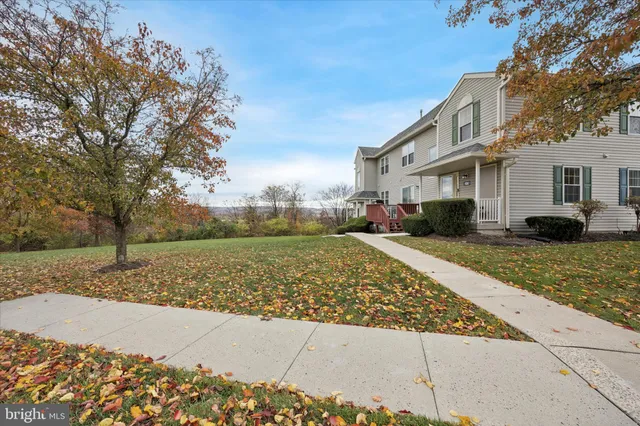 a front view of a house with a yard and trees