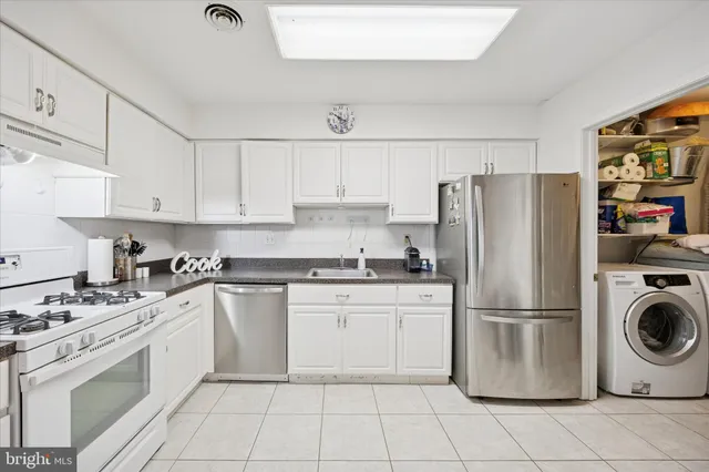 a kitchen with appliances a sink and cabinets