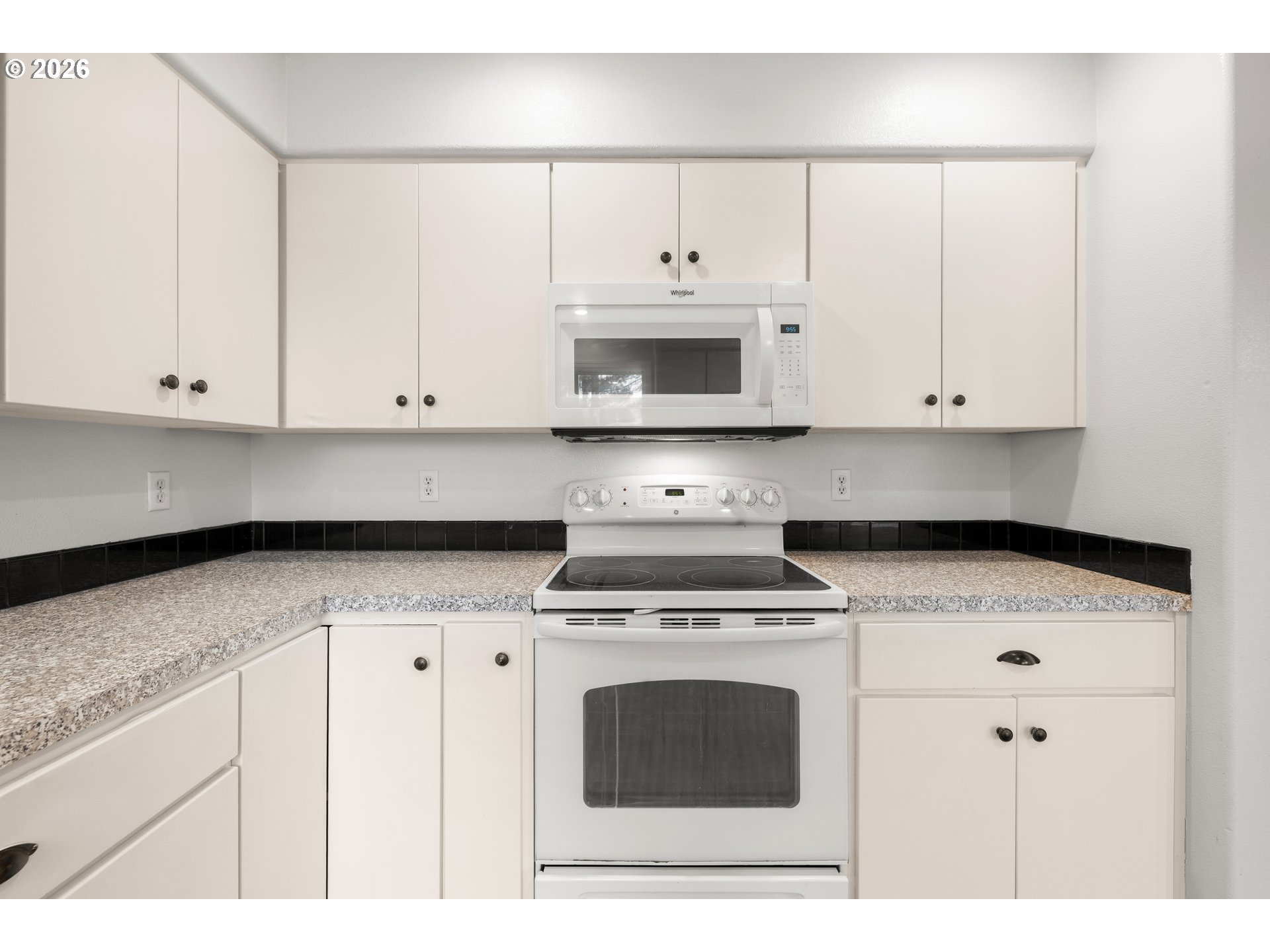 5572 Northwest 165th Place Portland, OR 97229 - Photo 11 of 48 a kitchen with granite countertop white cabinets and white appliances