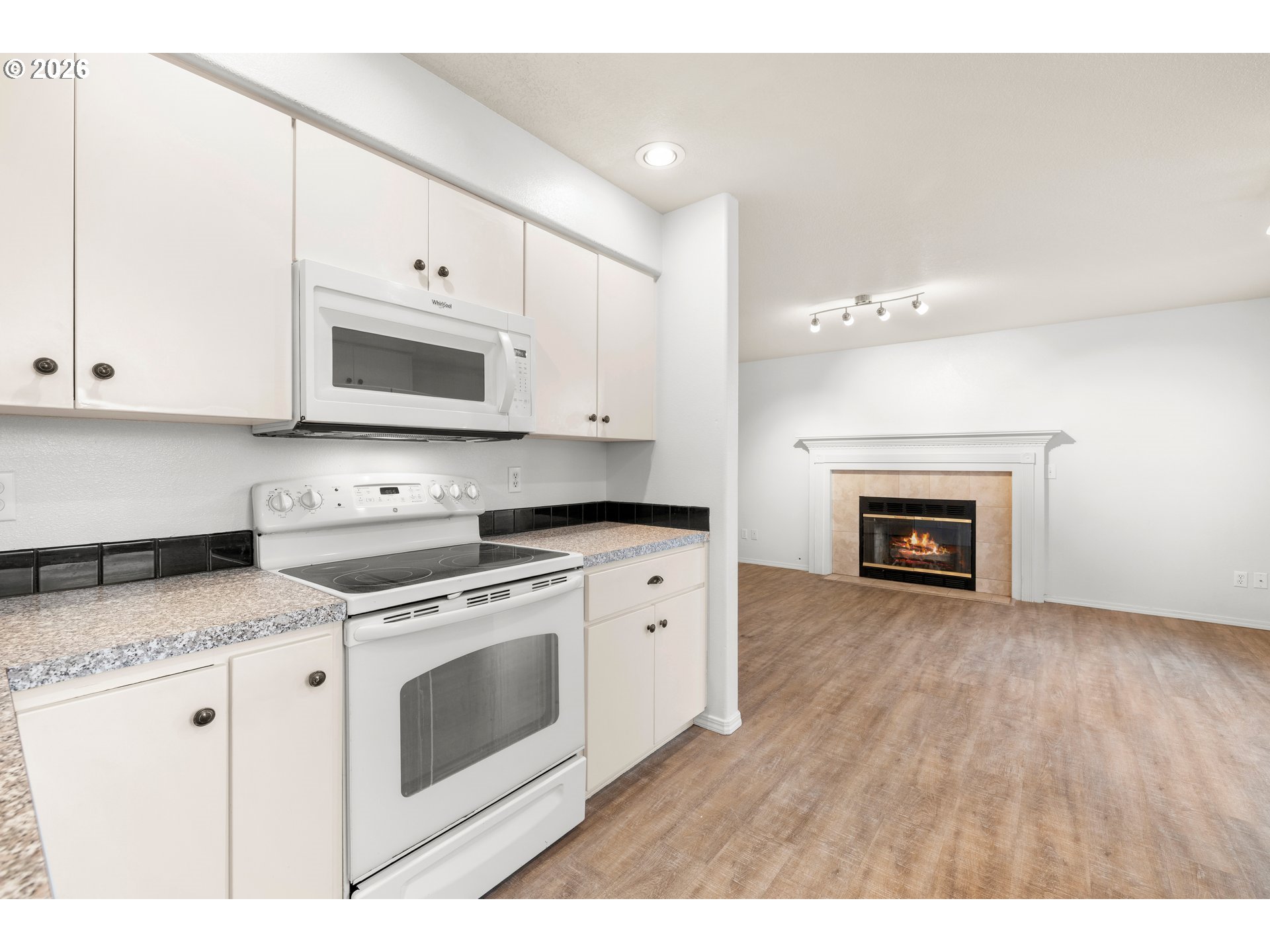 5572 Northwest 165th Place Portland, OR 97229 - Photo 13 of 48 a kitchen with granite countertop white cabinets and white appliances