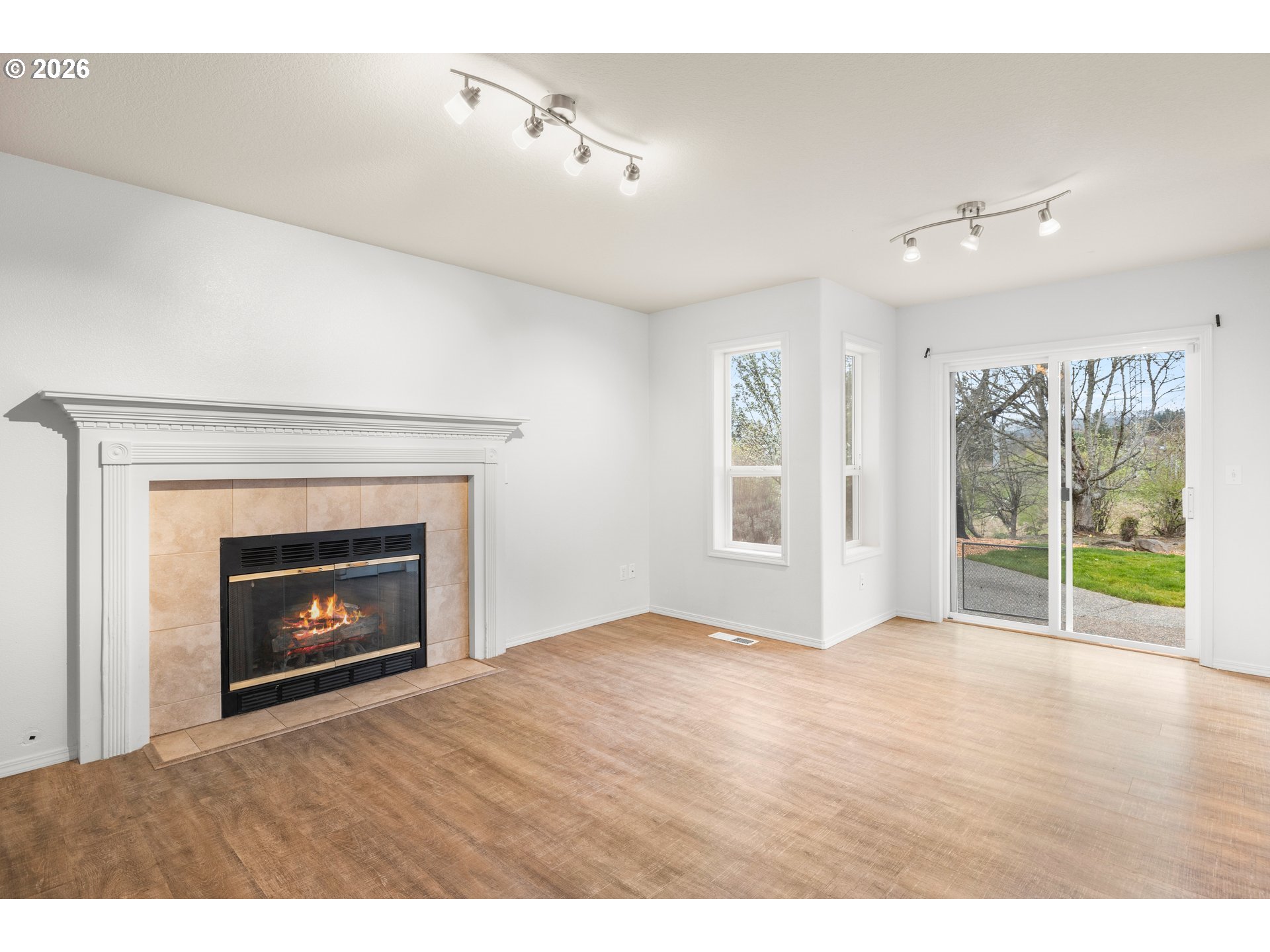 5572 Northwest 165th Place Portland, OR 97229 - Photo 18 of 48 a view of an empty room with wooden floor fireplace and a window