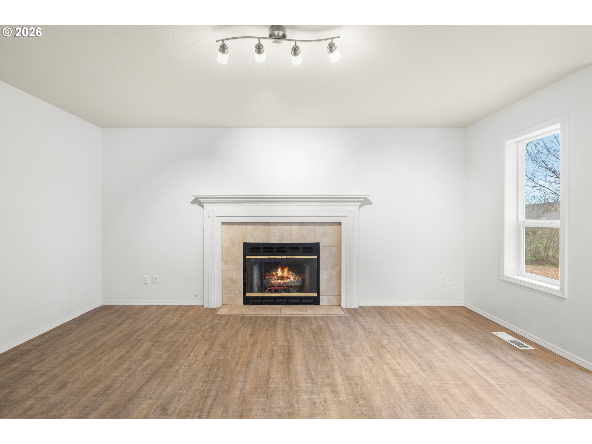 5572 Northwest 165th Place Portland, OR 97229 - Photo 19 of 48 a view of an empty room with wooden floor and a window