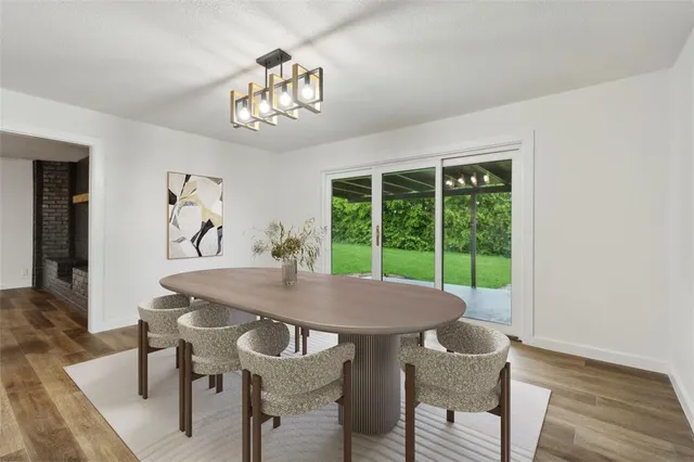 a view of a dining room with furniture a chandelier and wooden floor