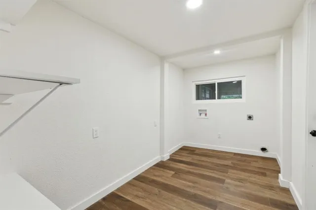 a view of a room with wooden floor and white walls