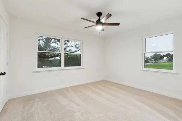 en empty room with window and ceiling fan