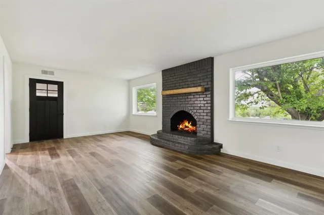 a living room with a fireplace and a floor to ceiling window