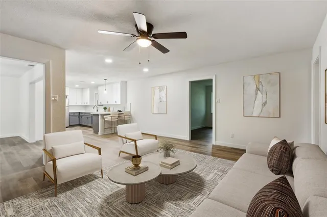 a living room with furniture and a view of kitchen