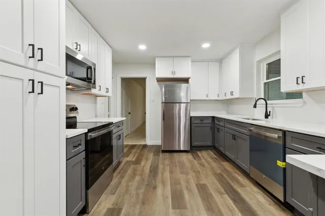 a kitchen with stainless steel appliances a refrigerator stove microwave and sink