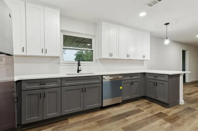 a kitchen with stainless steel appliances granite countertop a sink and cabinets with wooden floor
