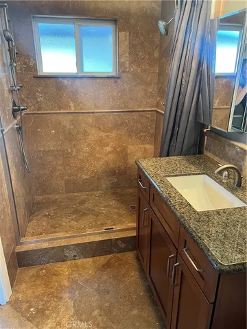 a bathroom with a granite countertop sink and a mirror