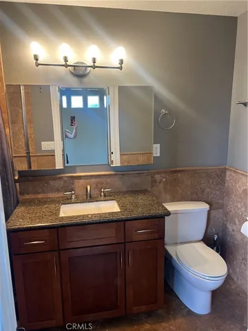 a bathroom with a granite countertop toilet sink and a mirror
