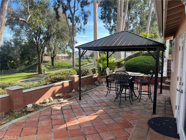 a view of a patio with a table chairs and a yard
