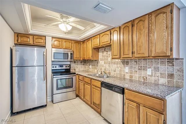 a kitchen with stainless steel appliances granite countertop a refrigerator and a sink