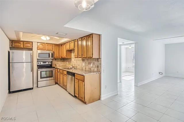 a kitchen with stainless steel appliances granite countertop a refrigerator and a stove top oven