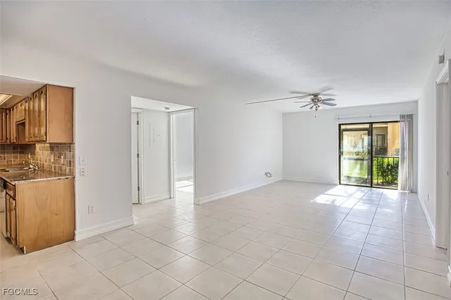 a view of an empty room with window and cabinet