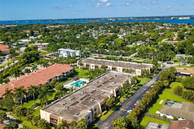 an aerial view of a city with lots of residential buildings ocean and mountain view in back