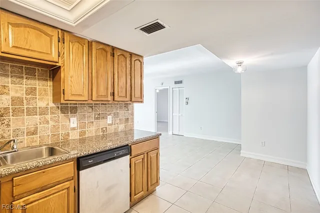 a kitchen with granite countertop a sink stainless steel appliances and cabinets