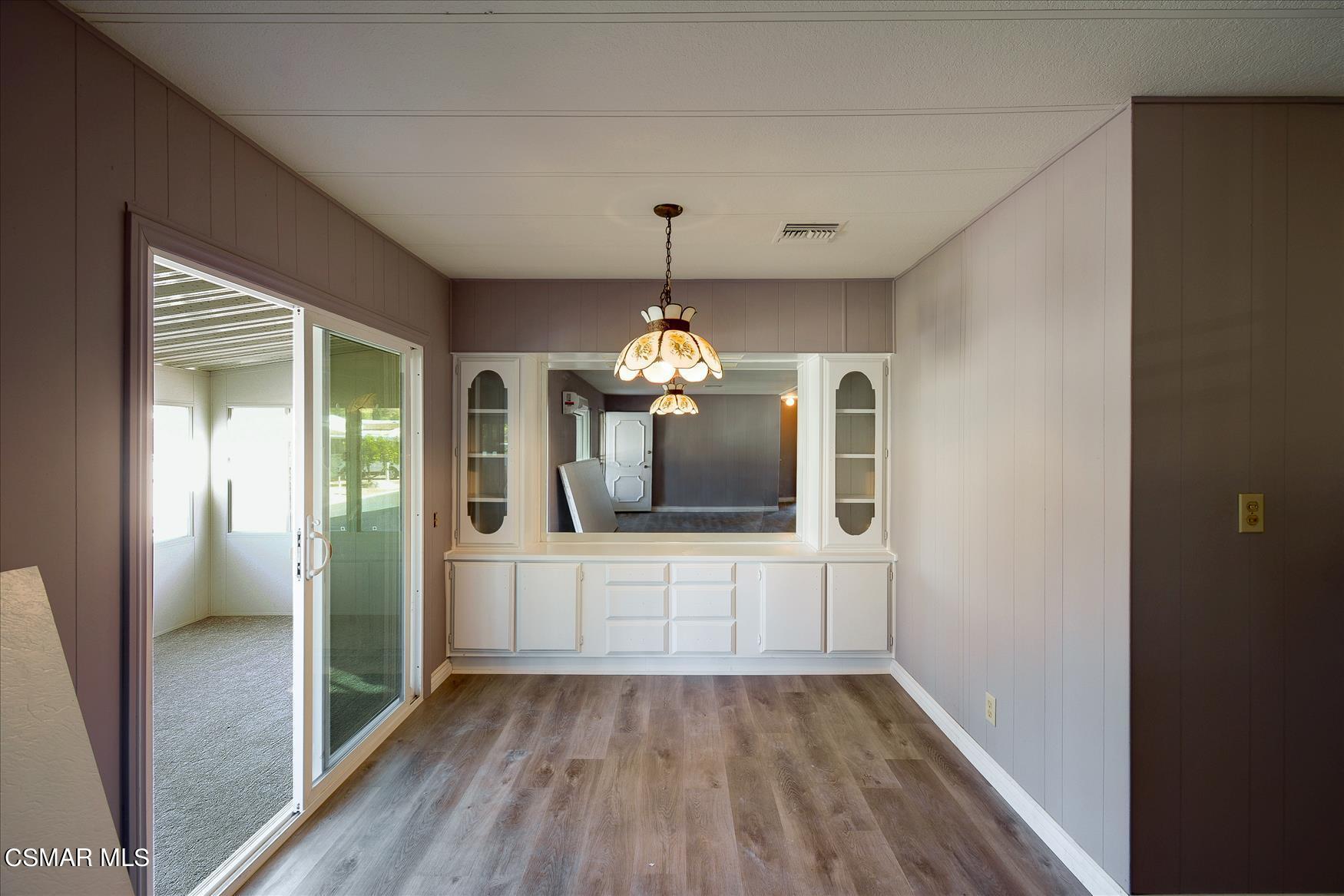 6480 Katherine Road, Unit 21 Simi Valley, CA 93063 - Photo 19 of 42 a view of a room with wooden floor chandelier and windows