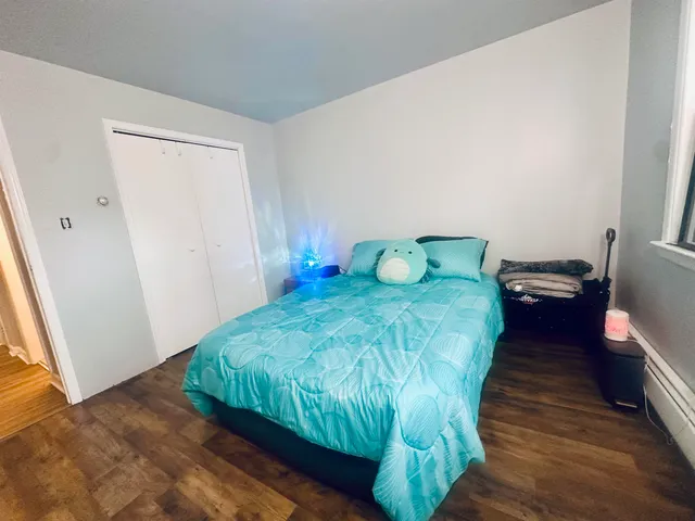 a bedroom with a bed and wooden floor