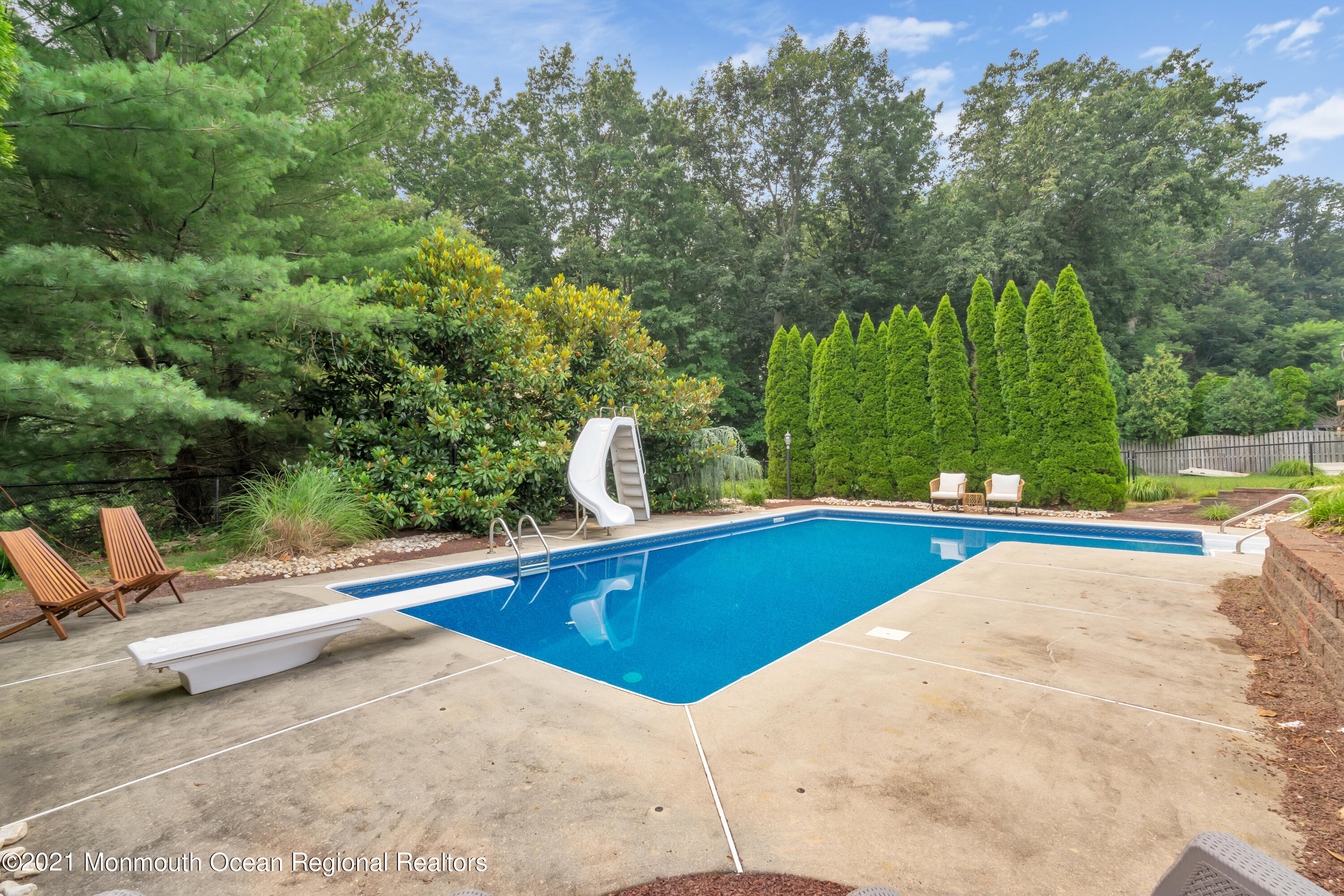 20 Highland Drive Jackson, NJ 08527 - Photo 59 of 62 a view of a swimming pool with a lounge chair and trees in the background