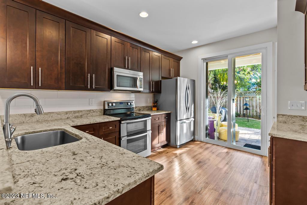 311 E Street St. Augustine, FL 32080 - Photo 11 of 40 a kitchen with kitchen island granite countertop a refrigerator stove and sink