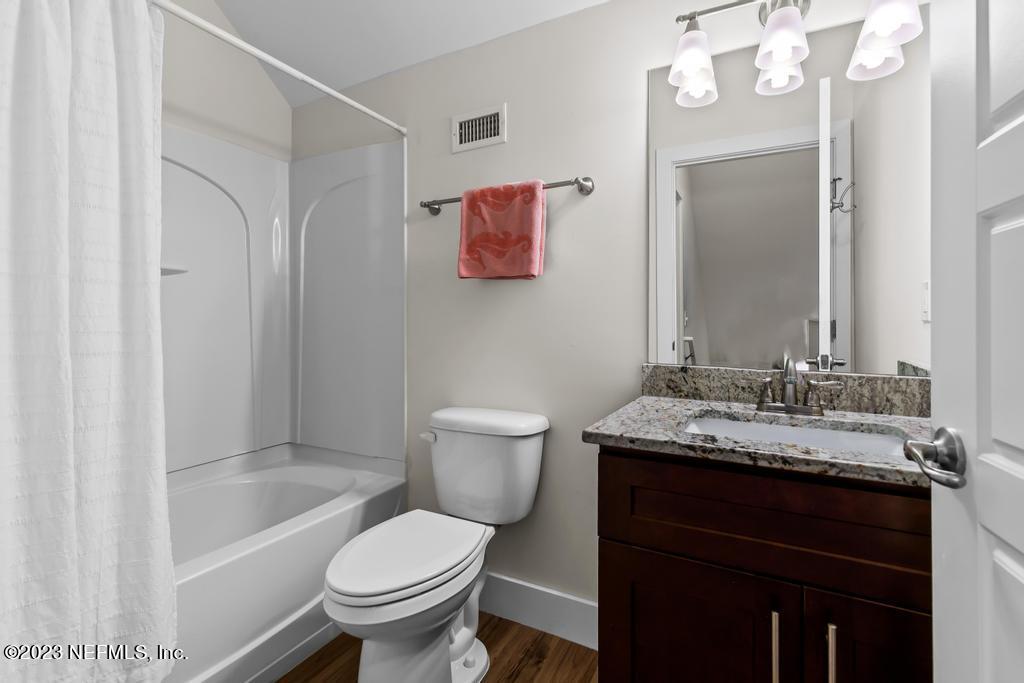 311 E Street St. Augustine, FL 32080 - Photo 19 of 40 a bathroom with a granite countertop toilet sink and mirror