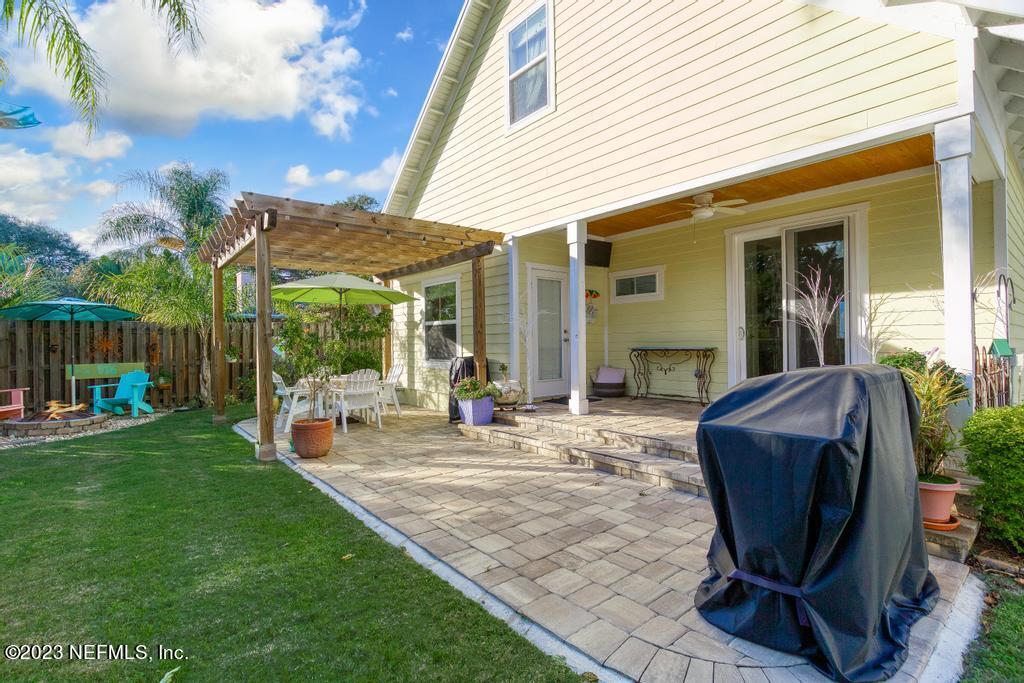 311 E Street St. Augustine, FL 32080 - Photo 26 of 40 a view of a backyard with table and chairs and wooden fence