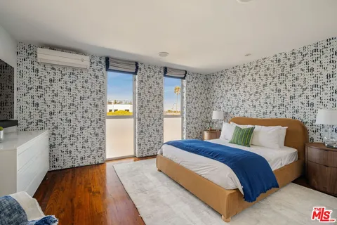a bedroom with a bed and a wall painting