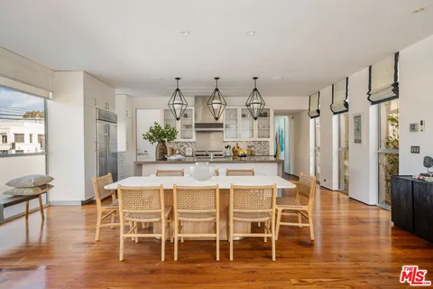 a kitchen with stainless steel appliances kitchen island granite countertop a table and chairs in it