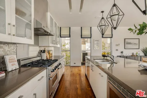 a kitchen with stainless steel appliances a sink a stove and cabinets