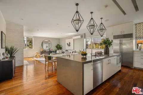 a kitchen with stainless steel appliances granite countertop a lot of counter space and wooden floor