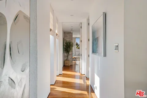 a view of a hallway with a livingroom and furniture