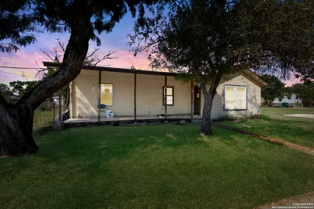 a view of a yard in front of a house with large tree