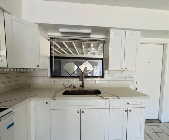 a kitchen with a sink cabinets and window