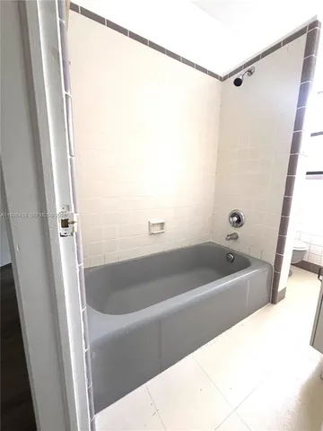 a bath tub sitting next to a white sink and vanity