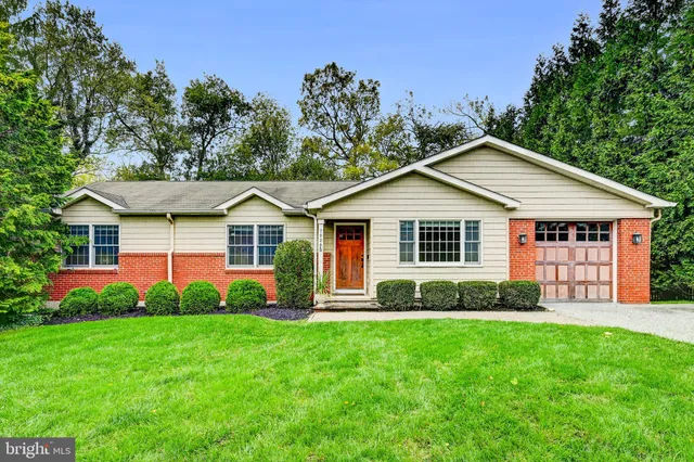 a front view of a house with a yard and green space