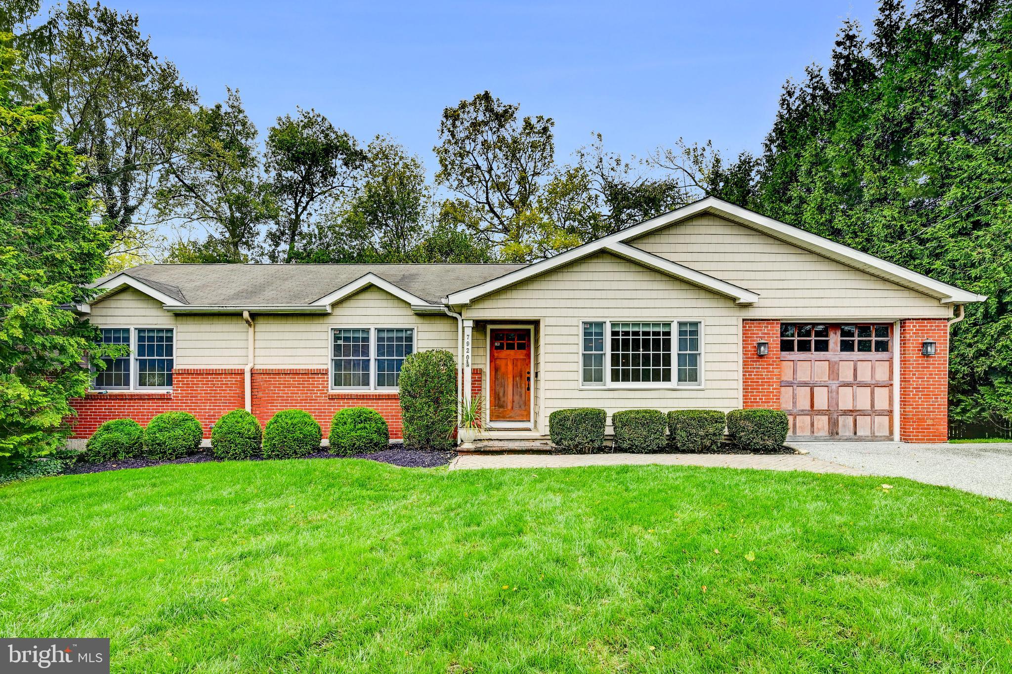 a front view of a house with a yard and green space