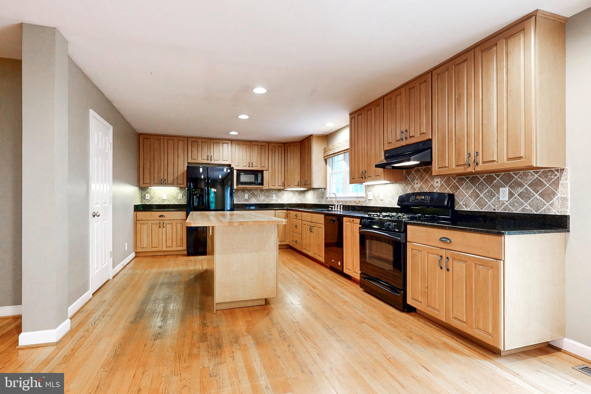 7920 Springway Road Baltimore, MD 21204 - Photo 11 of 49 a large kitchen with stainless steel appliances granite countertop a stove a sink dishwasher and a microwave oven with wooden floor