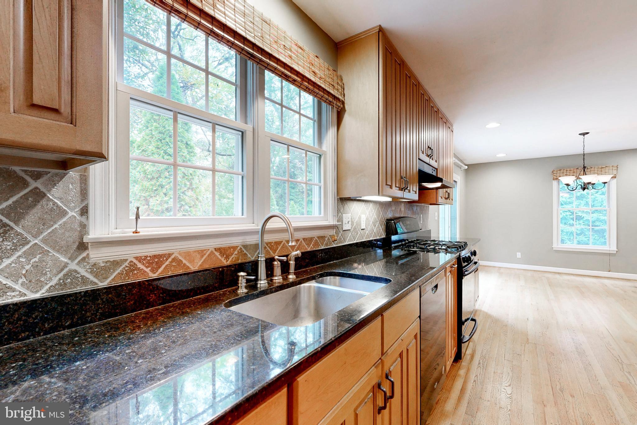 7920 Springway Road Baltimore, MD 21204 - Photo 13 of 49 a kitchen with stainless steel appliances granite countertop a sink a stove and a wooden floors