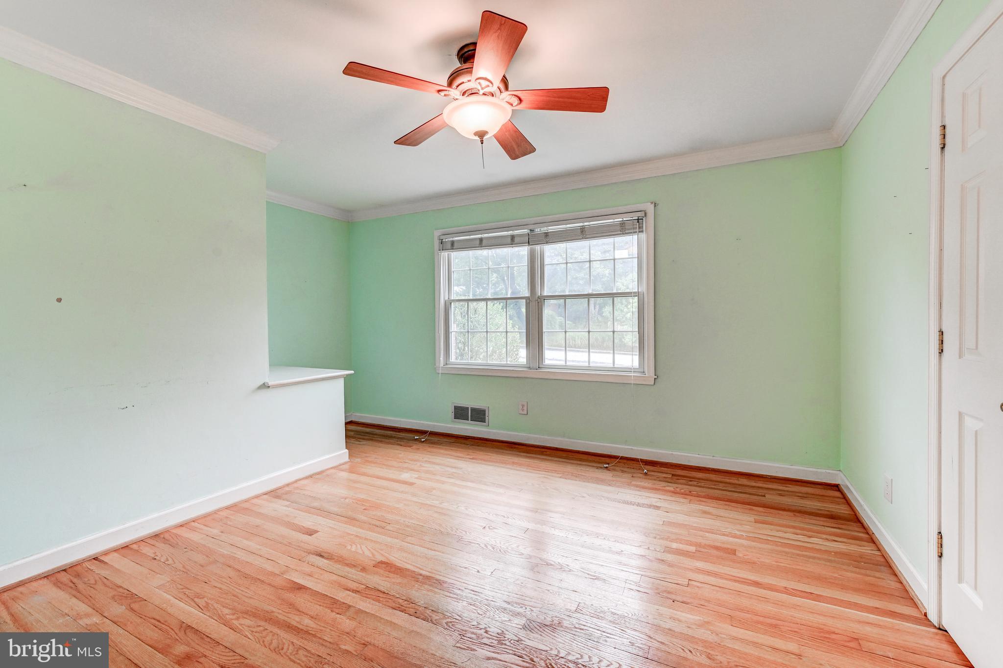 7920 Springway Road Baltimore, MD 21204 - Photo 22 of 49 an empty room with wooden floor chandelier fan and windows