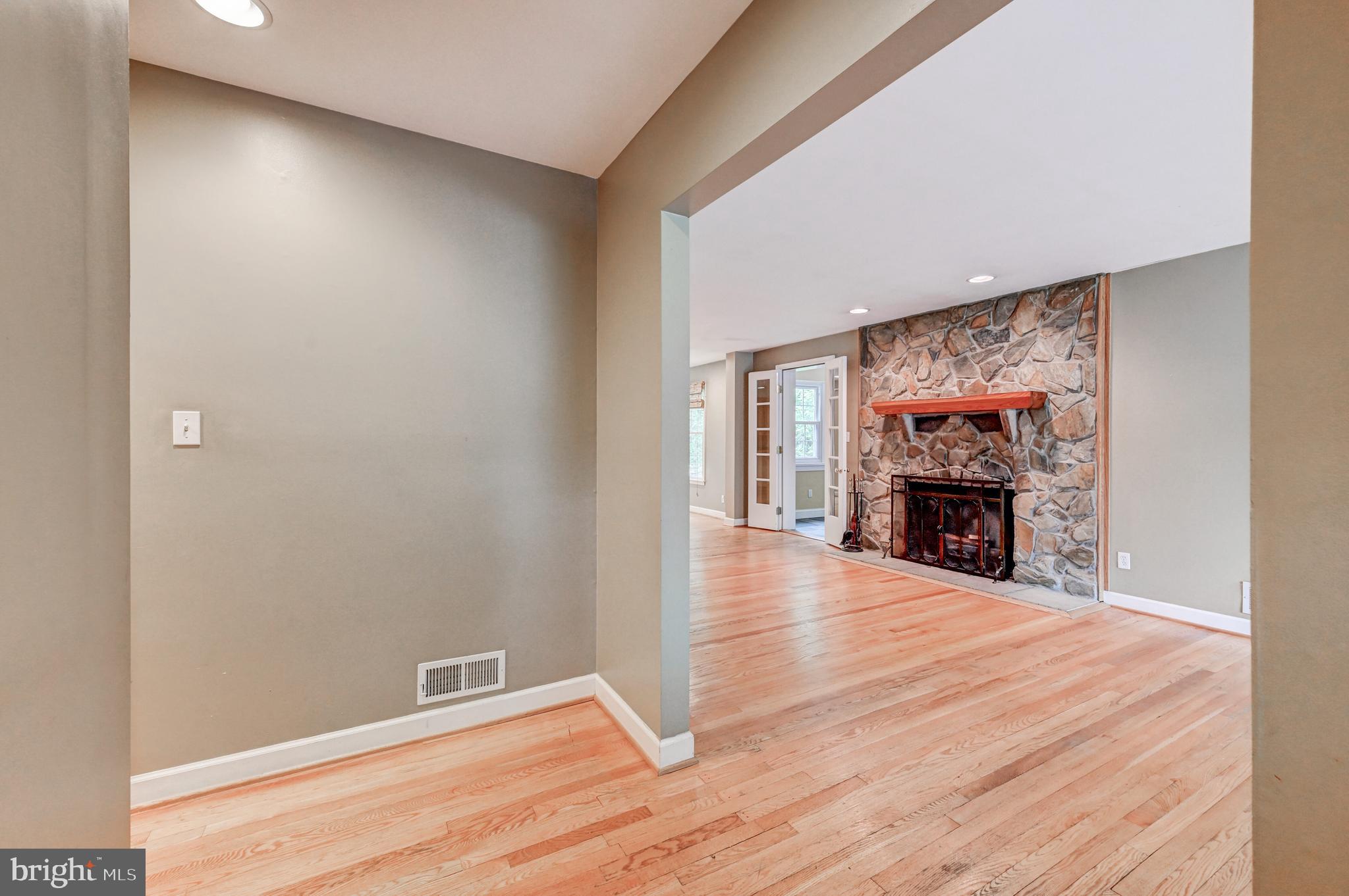 7920 Springway Road Baltimore, MD 21204 - Photo 6 of 49 a view of an empty room with wooden floor fireplace and a window