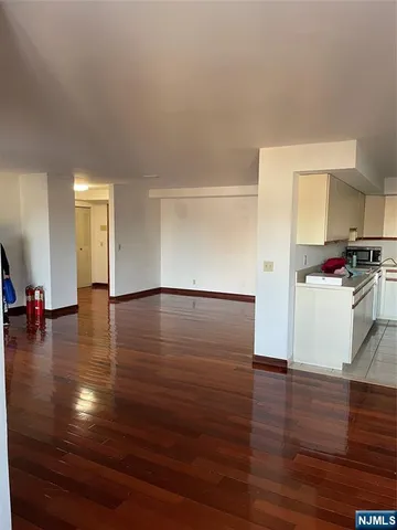 a view of a kitchen with wooden floor and cabinets