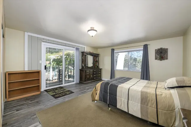 a spacious bedroom with a bed and a dresser next to a window