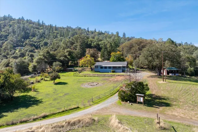a view of swimming pool with outdoor seating and trees in the background