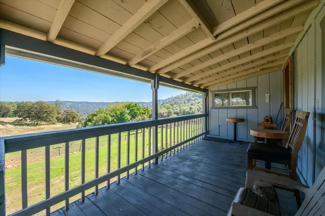 a view of a porch with furniture and wooden floor