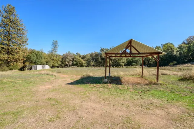 a view of a house with a garden and sitting area