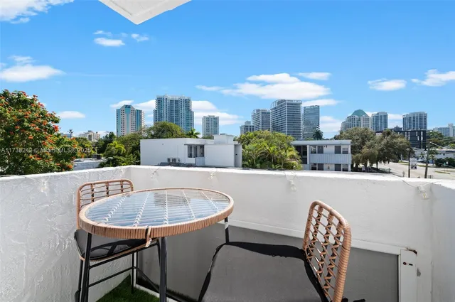 a balcony with table and chairs