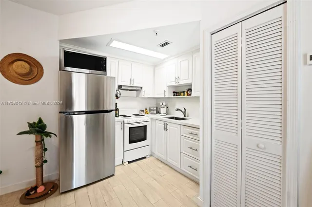 a kitchen with cabinets stainless steel appliances and a window