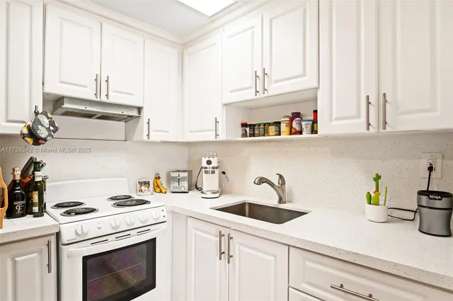 a kitchen with white cabinets and white appliances