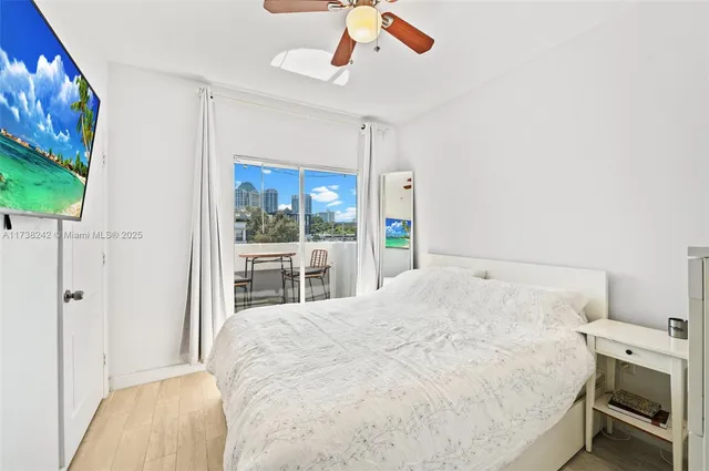a spacious bedroom with a bed and a flat screen tv